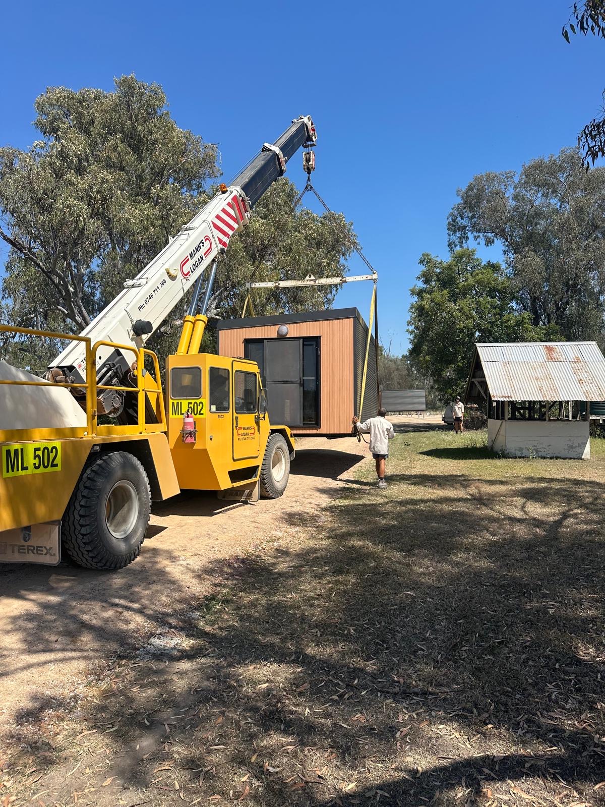 Crane placing portable worker accommodation on a regional site